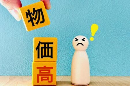 Kanji blocks spell '物価高' (rising prices) with a worried figure and a yellow exclamation mark nearby.