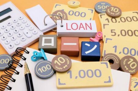 Colorful desk scene illustrating a loan concept with a LOAN tag, calculator, currency notes, coins, and office supplies